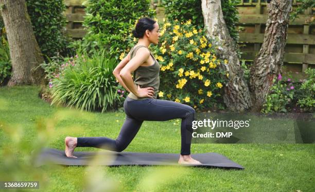 shot of a mature woman doing forward lunges while exercising outdoors - female yoga garden stock pictures, royalty-free photos & images