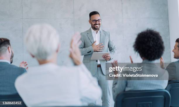 businesspeople applauding during a seminar in conference hall. - presenter stock pictures, royalty-free photos & images