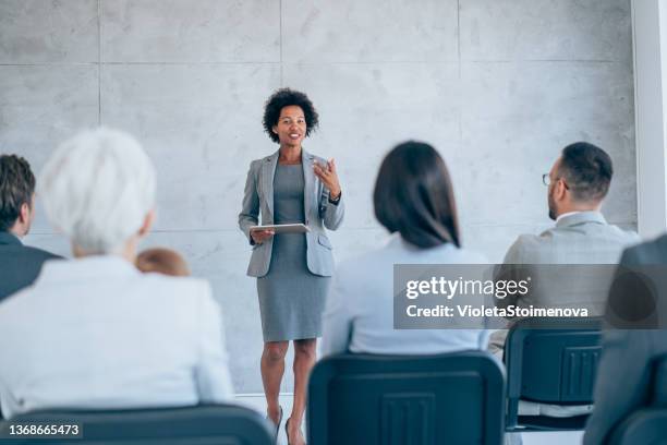 geschäftsfrau, die mit kollegen präsentation. - african american speaking to an audience stock-fotos und bilder