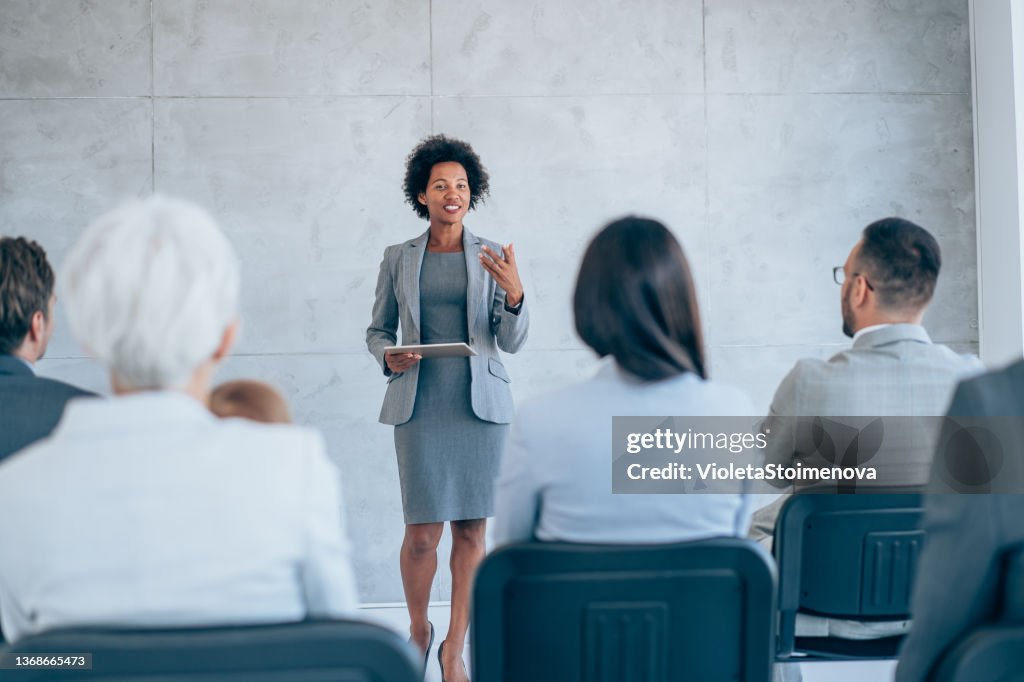 Businesswoman giving presentation with colleagues.