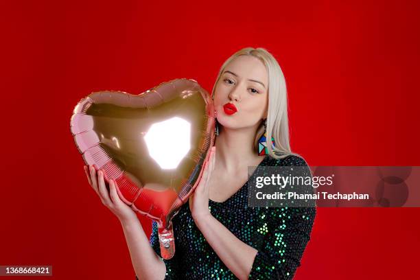 beautiful woman holding heart shape balloon - red lipstick kiss stock pictures, royalty-free photos & images