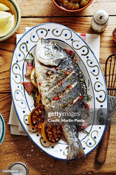 oven roasted fish on platter on table - seafood platter stockfoto's en -beelden