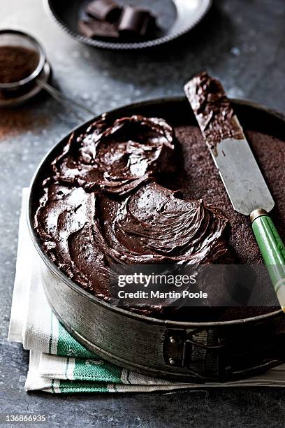 chocolate icing on a chocolate cake - chocolate cake stock pictures, royalty-free photos & images