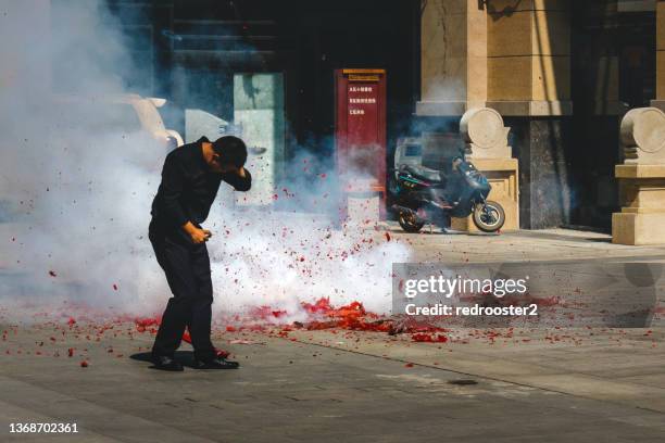 an asian man light huge amount of firecrackers trying to escape - fire prevention stock pictures, royalty-free photos & images