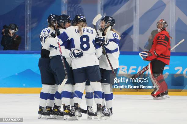 Minnamari Tuominen of Team Finland is congratulated by their teammates after scoring a goal past Ann-Renee Desbiens of Team Canada in the first...