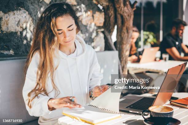beautiful woman working on laptop in outdoor cafe. - blogger woman stock pictures, royalty-free photos & images