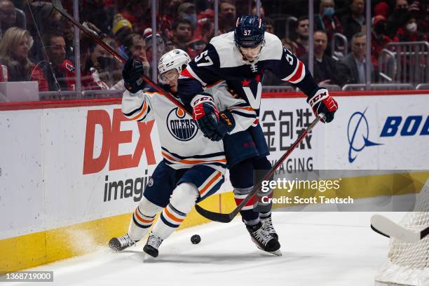 Trevor van Riemsdyk of the Washington Capitals and Kailer Yamamoto of the Edmonton Oilers battle for the puck during the first period of the game at...