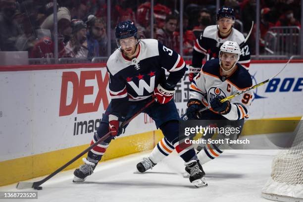 Nick Jensen of the Washington Capitals skates with the puck as Connor McDavid of the Edmonton Oilers defends during the third period of the game at...