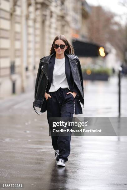 Diane Batoukina wears sunglasses from Chanel, a white t-shirt from Munthe, a navy blue stripped oversized blazer jacket from Munthe, matching navy...