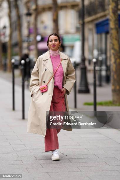 Maria Rosaria Rizzo wears gold large earrings, a pale pink ribbed wool turtleneck pullover, a pink wool braided pattern pullover from Imprevu...