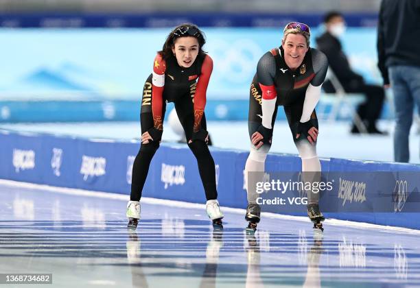 Ahenaer Adake of Team China and Claudia Pechstein of Team Germany react after the Women's 3000m on day one of the Beijing 2022 Winter Olympic Games...