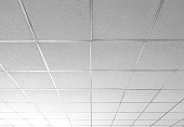 Background and texture of white T bar ceiling tiles with nice light gradation in low angle and perspective view