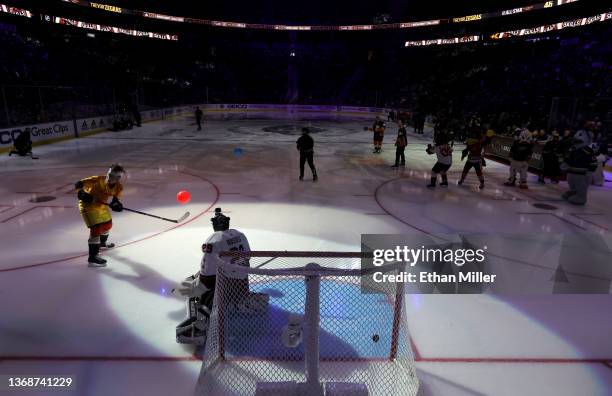 Trevor Zegras of the Anaheim Ducks, dressed as the character Peter La Fleur from the movie "Dodgeball: A True Underdog Story," shoots the puck while...