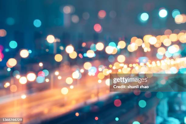 defocused image of illuminated city at night - bright lights stock pictures, royalty-free photos & images