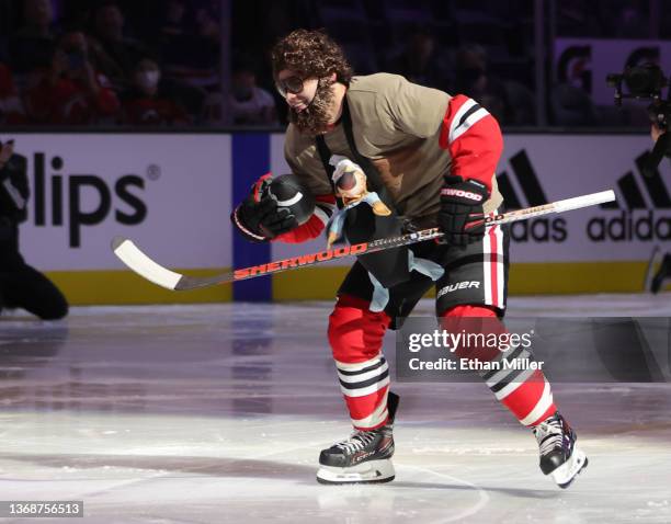 Alex DeBrincat of the Chicago Blackhawks, dressed as Zach Galifianakis' character from The Hangover" movie, carries a football as he competes in the...