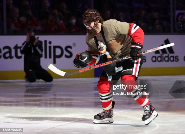 Alex DeBrincat of the Chicago Blackhawks, dressed as Zach Galifianakis' character from The Hangover" movie, carries a football as he competes in the...