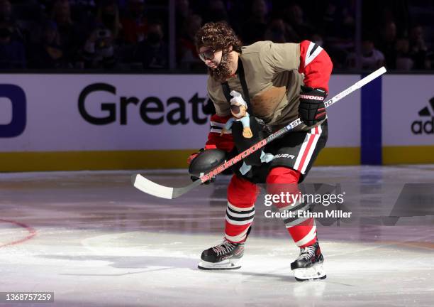 Alex DeBrincat of the Chicago Blackhawks, dressed as Zach Galifianakis' character from The Hangover" movie, carries a football as he competes in the...