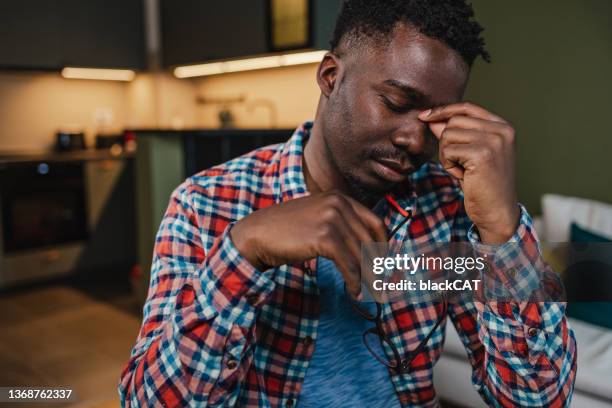 junger kerl hat einen stressigen tag und kopfschmerzen - winterdepression stock-fotos und bilder