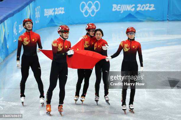 Team China celebrate winning the Gold medal during the Mixed Team Relay Final A on day one of the Beijing 2022 Winter Olympic Games at Capital Indoor...