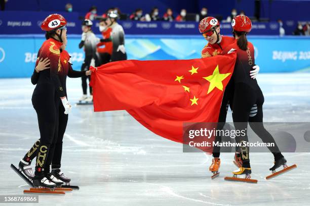 Team China celebrate winning the Gold medal during the Mixed Team Relay Final A on day one of the Beijing 2022 Winter Olympic Games at Capital Indoor...