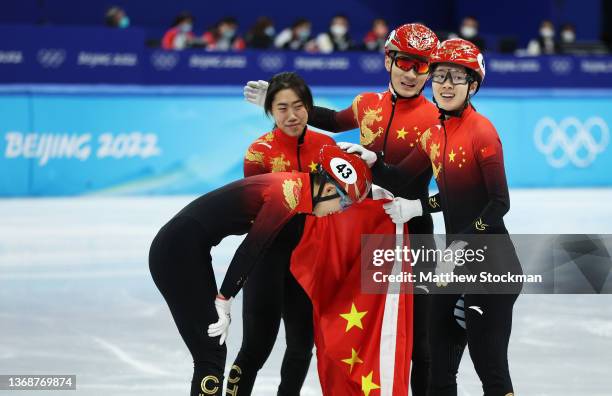 Team China celebrate winning the Gold medal during the Mixed Team Relay Final A on day one of the Beijing 2022 Winter Olympic Games at Capital Indoor...