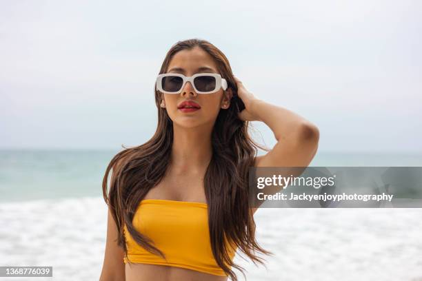 young woman standing on the beach - junge frau strand sand springen stock-fotos und bilder