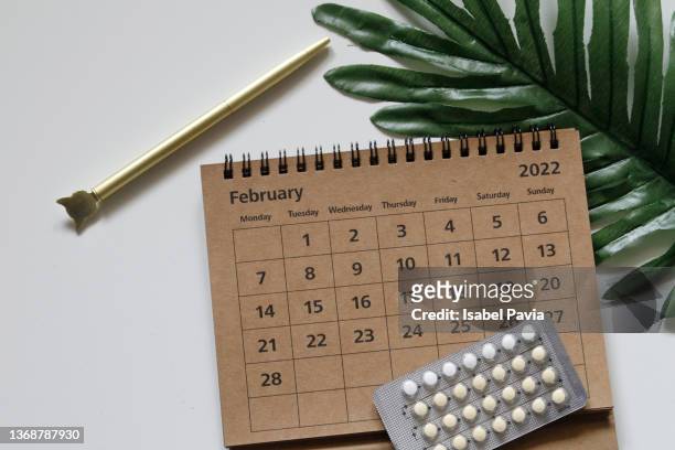 2022 february calendar and contraceptive blister pack on desk - contraceptive patch fotografías e imágenes de stock