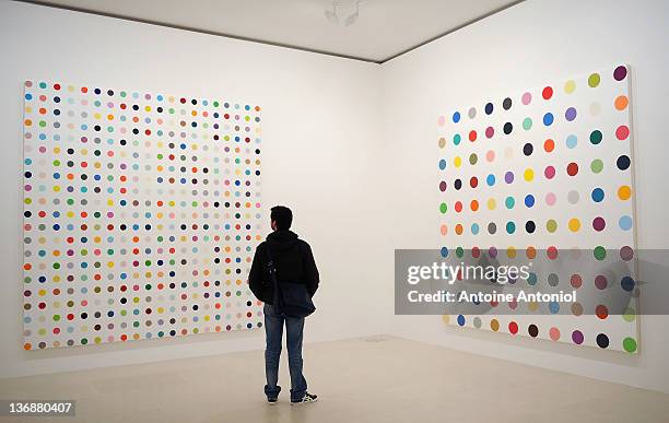 Visitor looks at a painting during the opening of Damien Hirst: 'The Complete Spot Paintings 1986-2011' Exhibition at Gagosian Gallery on January 12,...