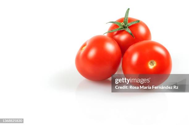 three fresh cherry tomatoes against a white background - cherry tomaten stock-fotos und bilder