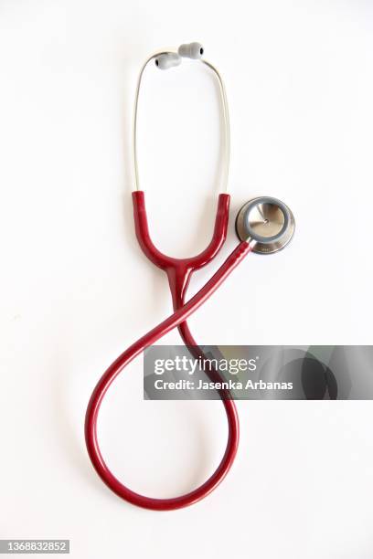 red stethoscope on white background - stethoskop stock-fotos und bilder