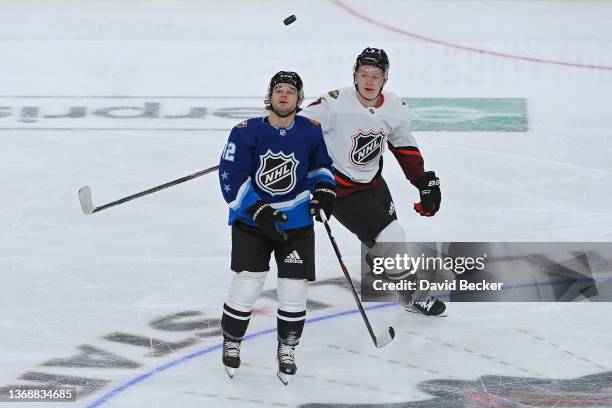 Alex DeBrincat of the Chicago Blackhawks and Brady Tkachuk of the Ottawa Senators battle for the puck during the game between the Atlantic Division...