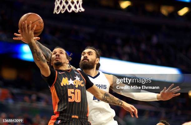 Cole Anthony of the Orlando Magic drives on Steven Adams of the Memphis Grizzlies during a game at Amway Center on February 05, 2022 in Orlando,...