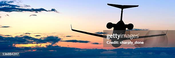 corporate jet airplane flying at dusk - small jet stock pictures, royalty-free photos & images