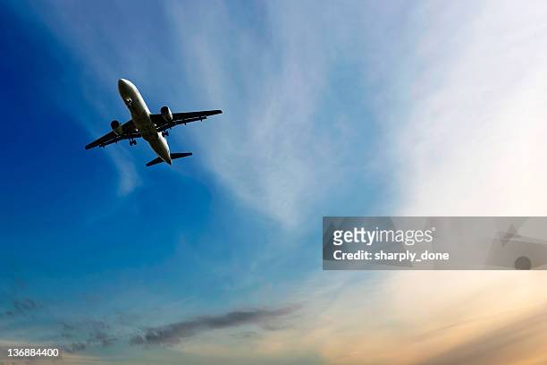 jet airplane landing at dusk - airplane in sky stock pictures, royalty-free photos & images