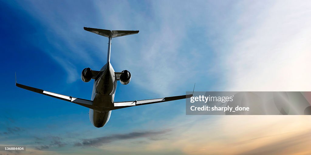 Corporate jet airplane flying at dusk