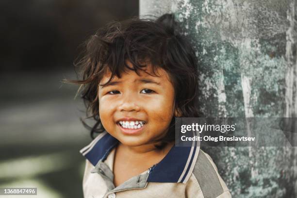 expressive portrait of smiling asian boy looking into camera close up. childhood - child poverty stock pictures, royalty-free photos & images