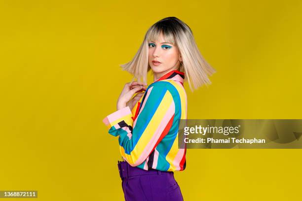 fashionable woman in colorful outfit - 胸に手を当てる ストックフォトと画像
