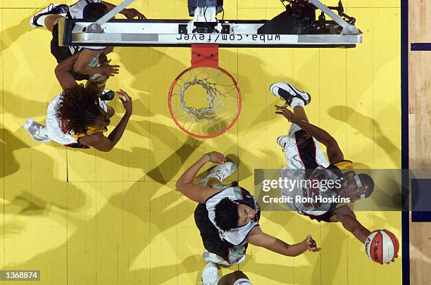 Tamika Catchings of the Indiana Fever grabs a rebound over Tamika Whitmore of the New York Liberty during Game One of the Eastern Conference...