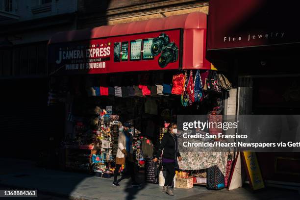 Pedestrians walk past a souvenir store on a largely deserted Grant Avenue in the Chinatown neighborhood of San Francisco, California Wednesday, Jan....