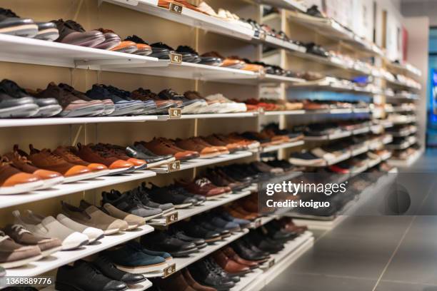 neat rows of shoes on a shelf - footwear store stock pictures, royalty-free photos & images