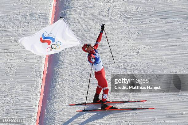 Alexander Bolshunov of Team ROC celebrates crossing the finish line to win the gold medal during the Men's Cross-Country Skiing 15km + 15km Skiathlon...