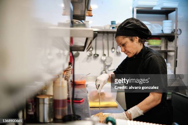 woman chef serving food at restaurant - classic spanish "tortilla de patatas" - tortilla de patatas photos et images de collection
