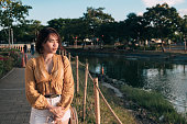 A lonely and depressed asian woman walks by the park to reminisce or contemplate and distract herself from worldly problems. Coping with breakup or other troubles.
