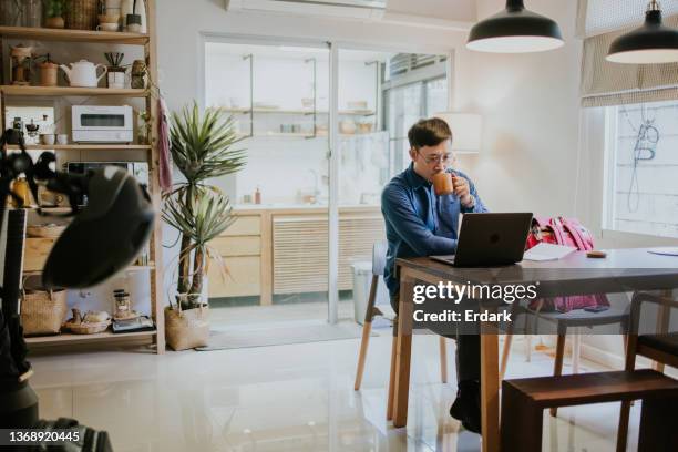 hombre asiático con estilo de vida sostenible usando taza de madera para su café. - masters degree fotografías e imágenes de stock