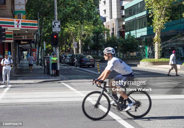 male cyclist on bourke st melbourne - straßenbahnstrecke stock-fotos und bilder