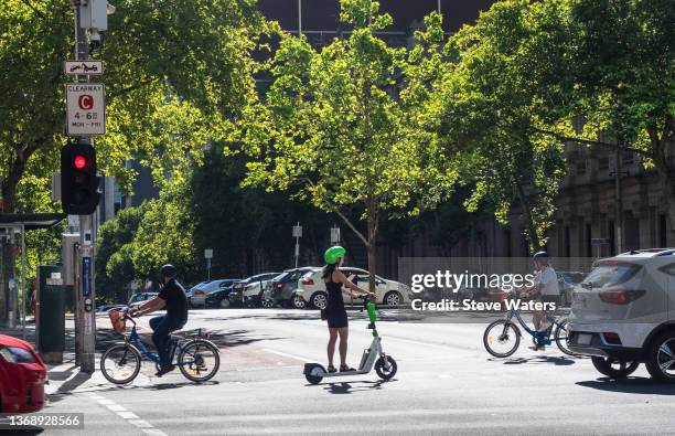 bicycles and e-scooter crossing lonsdale st, melbourne - car red light stock pictures, royalty-free photos & images