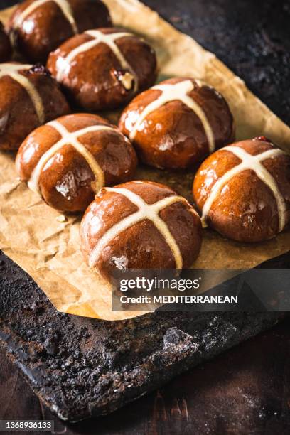 homemade easter hot cross buns just fresh baked over baking paper on black tray - hot cross bun stock pictures, royalty-free photos & images