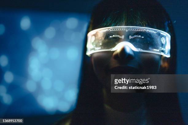 young woman is using futuristic glasses with technology on background - smart glasses stock pictures, royalty-free photos & images