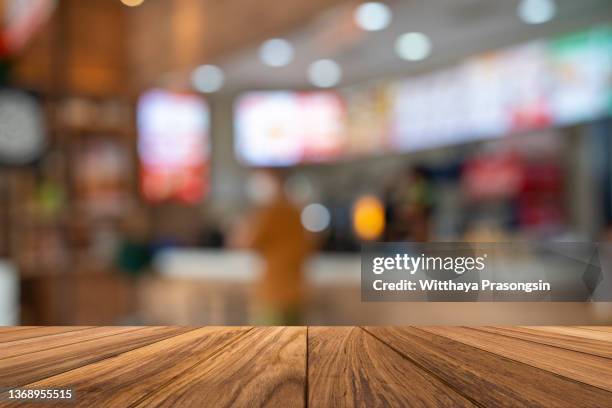 wood table top on blur restaurant interior background - barware stock-fotos und bilder