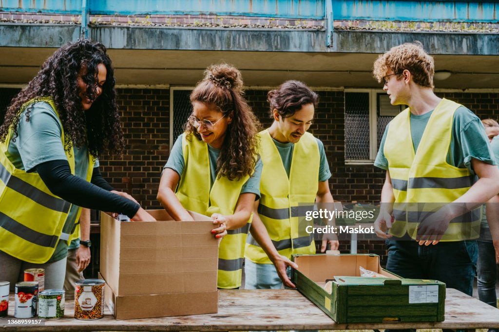Smiling male and female friends working at table in non-profit organization